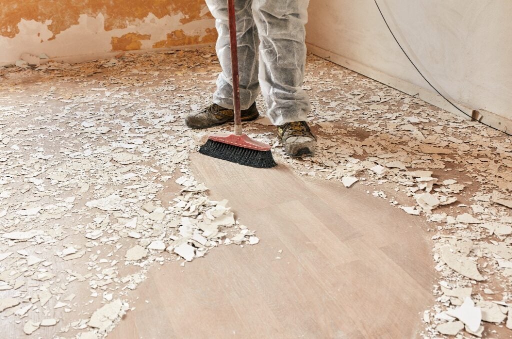 Builder sweeping the floor after renovation